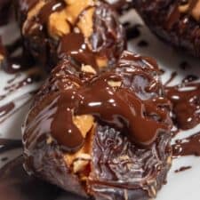A close up shot of peanut butter stuffed dates covered in melted vegan chocolate.