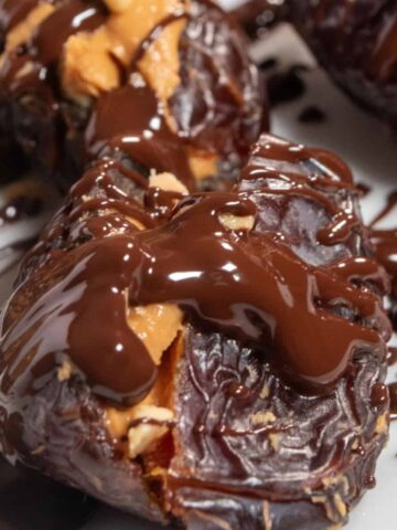 A close up shot of peanut butter stuffed dates covered in melted vegan chocolate.