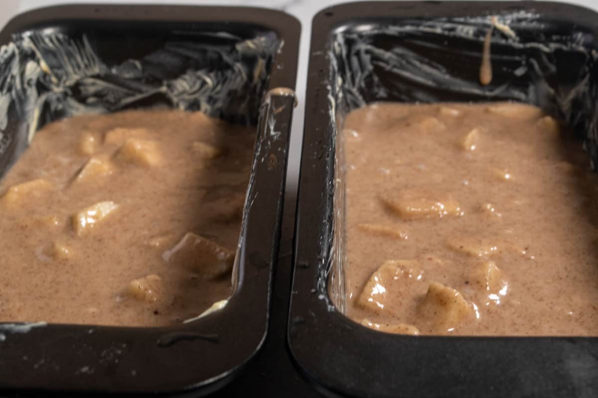 The cake batter has been poured into the two greased cake tins.