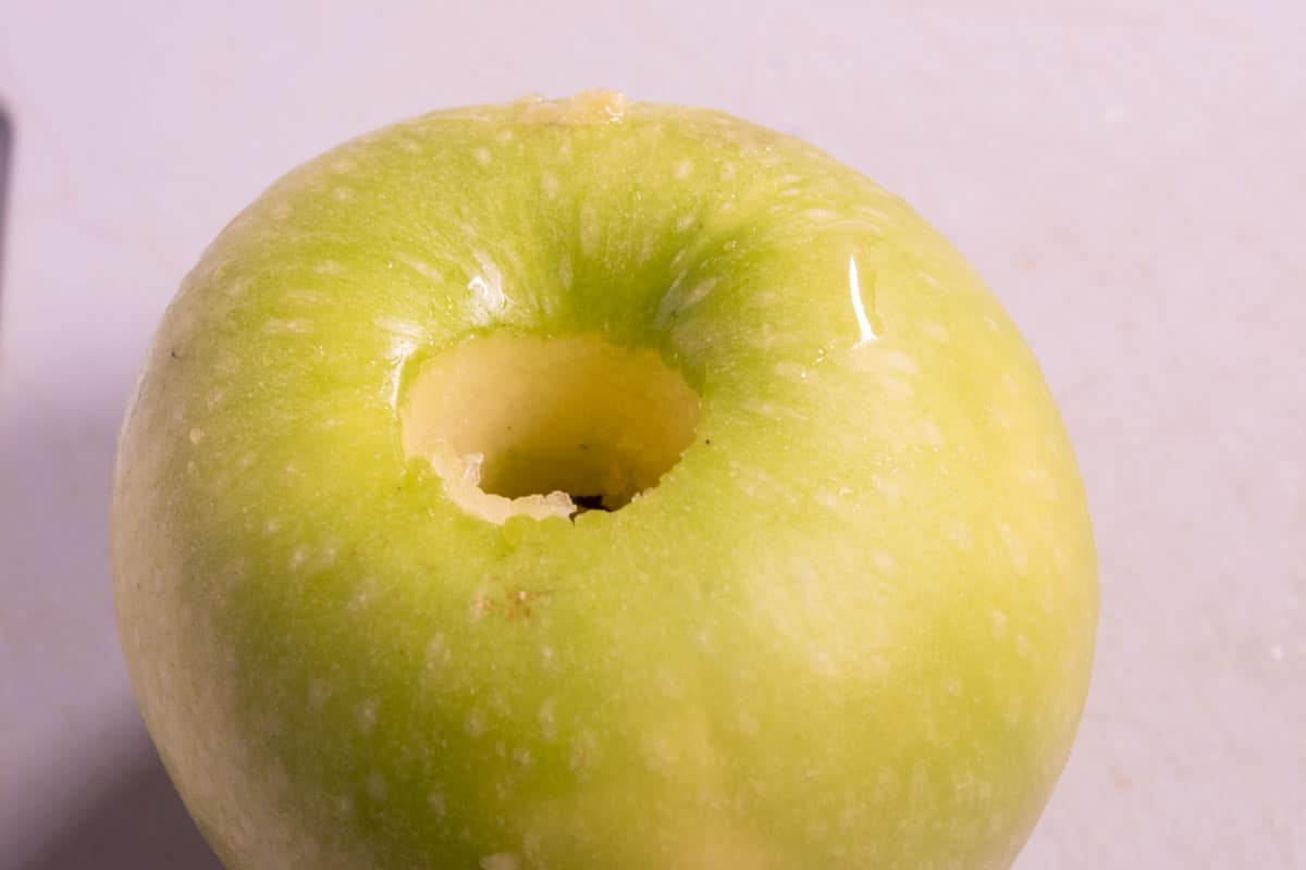 A Granny Smith apple has been cored.