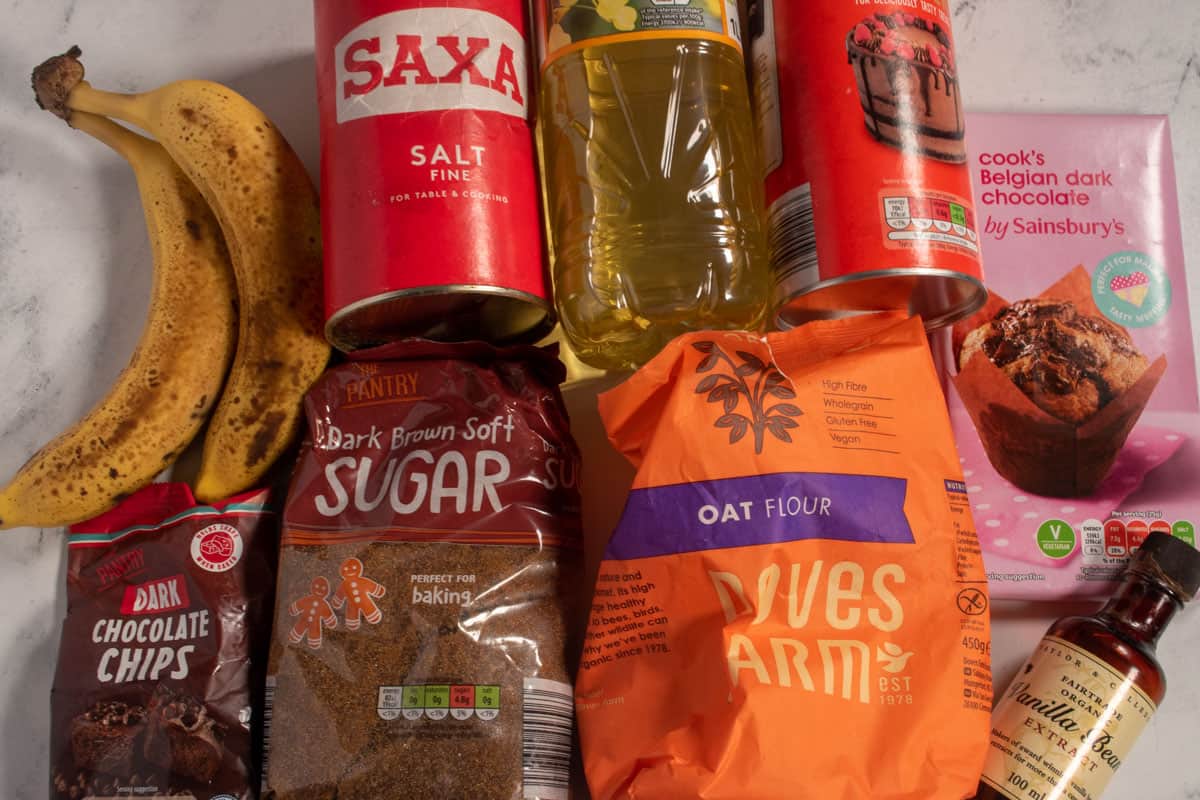 The ingredients that are required to make my vegan banana brownies recipe on a white, marble background.