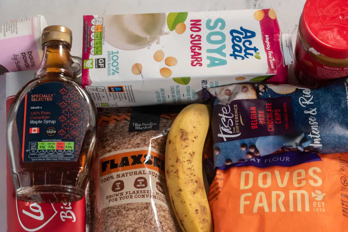 All the ingredients needed to make my vegan biscoff baked oats laid out over a white, marble background. 