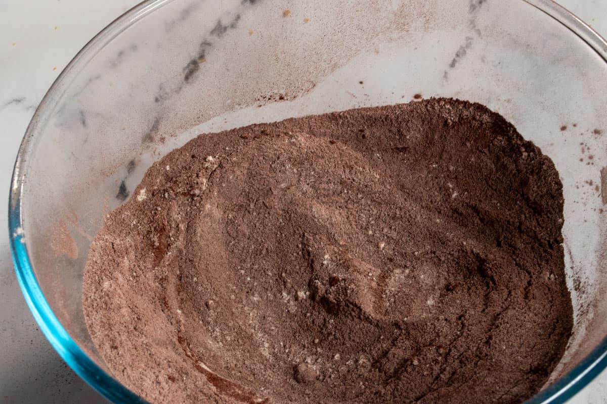 The dry chocolate cake ingredients inside a glass bowl.