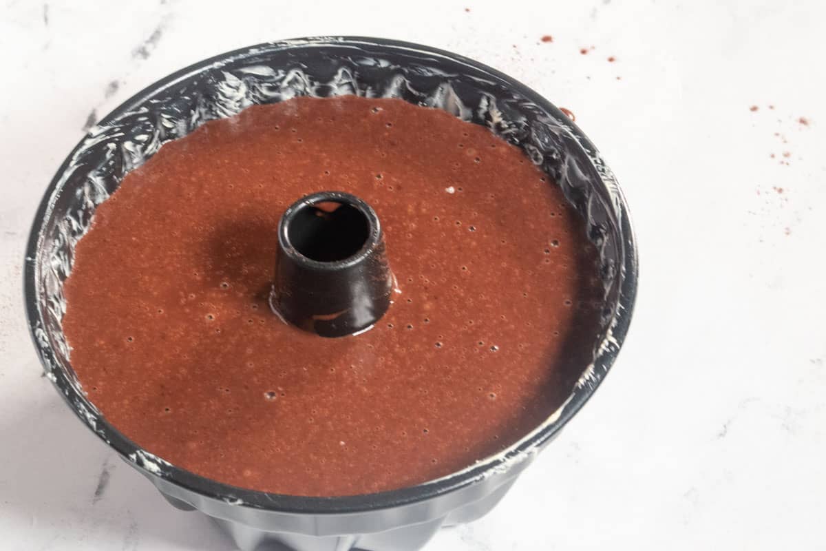 The vegan chocolate bundt cake batter has been poured into the tin.