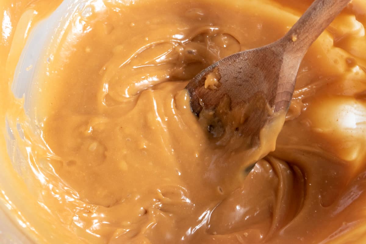 The peanut butter glaze is now smooth and creamy after the wet ingredients have been poured in.