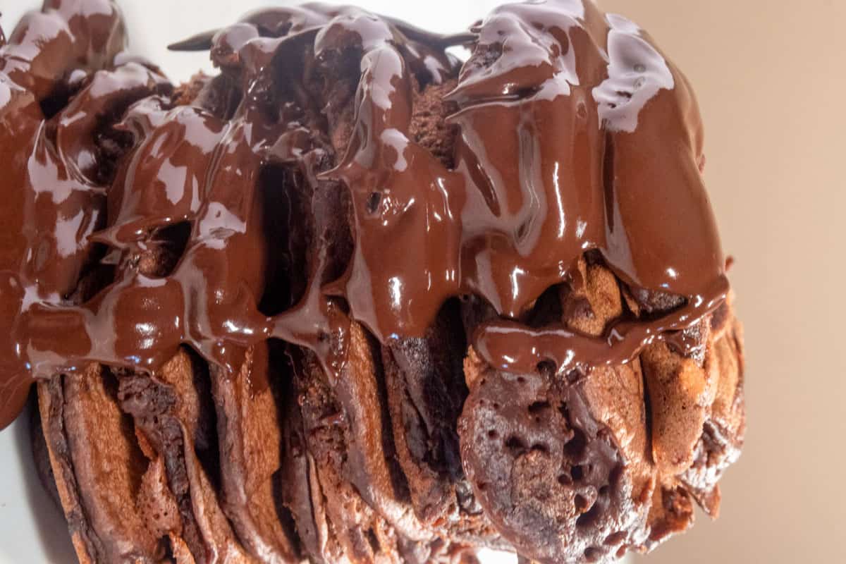 A stack of vegan double chocolate chip pancakes topped with plenty of dripping chocolate.