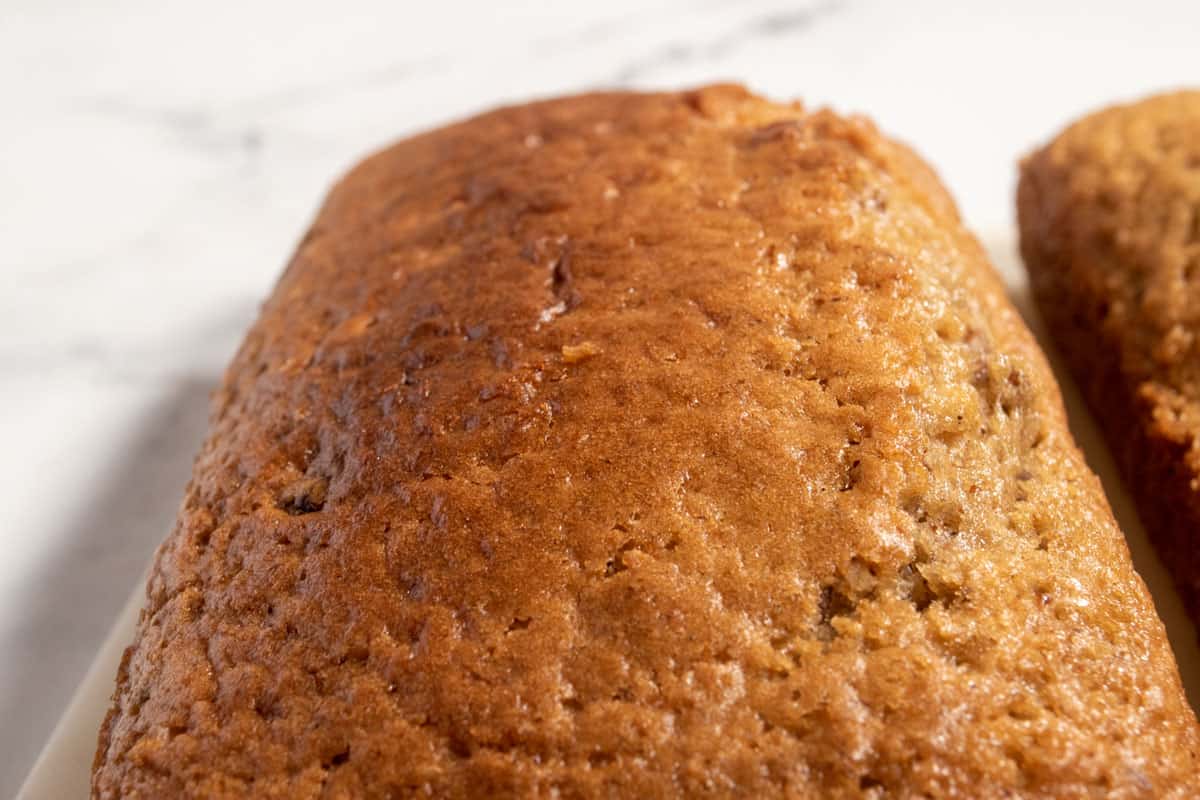 The cakes have been baked and are cooling down on white plates. They are golden brown. 