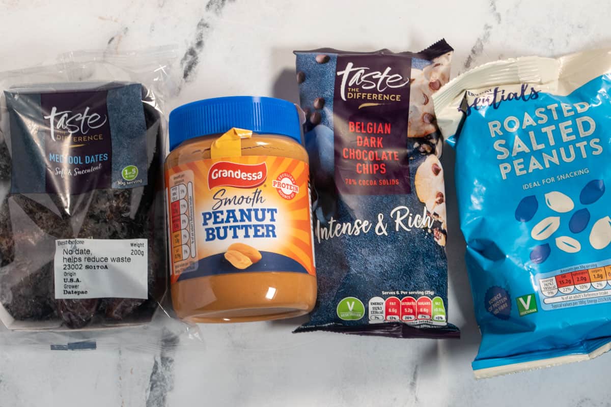 A photo of the four ingredients that are needed to make peanut butter stuffed dates. Medjool dates, peanut butter, peanuts and chocolate chips. 