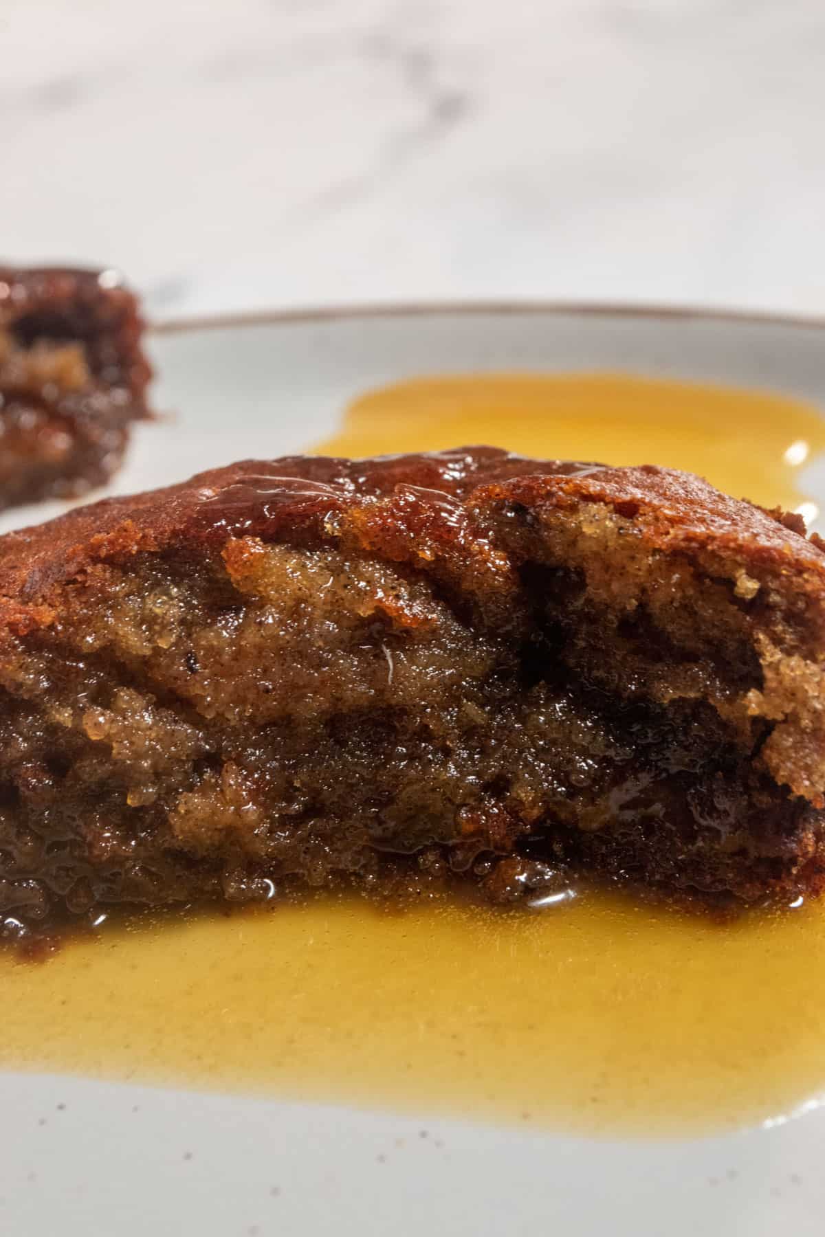 A sliced pudding cake. The inside of the cake is soaked in toffee sauce and is super moist.