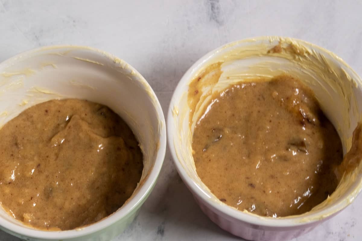 The vegan sticky toffee pudding batter has been poured into the two ramekins.