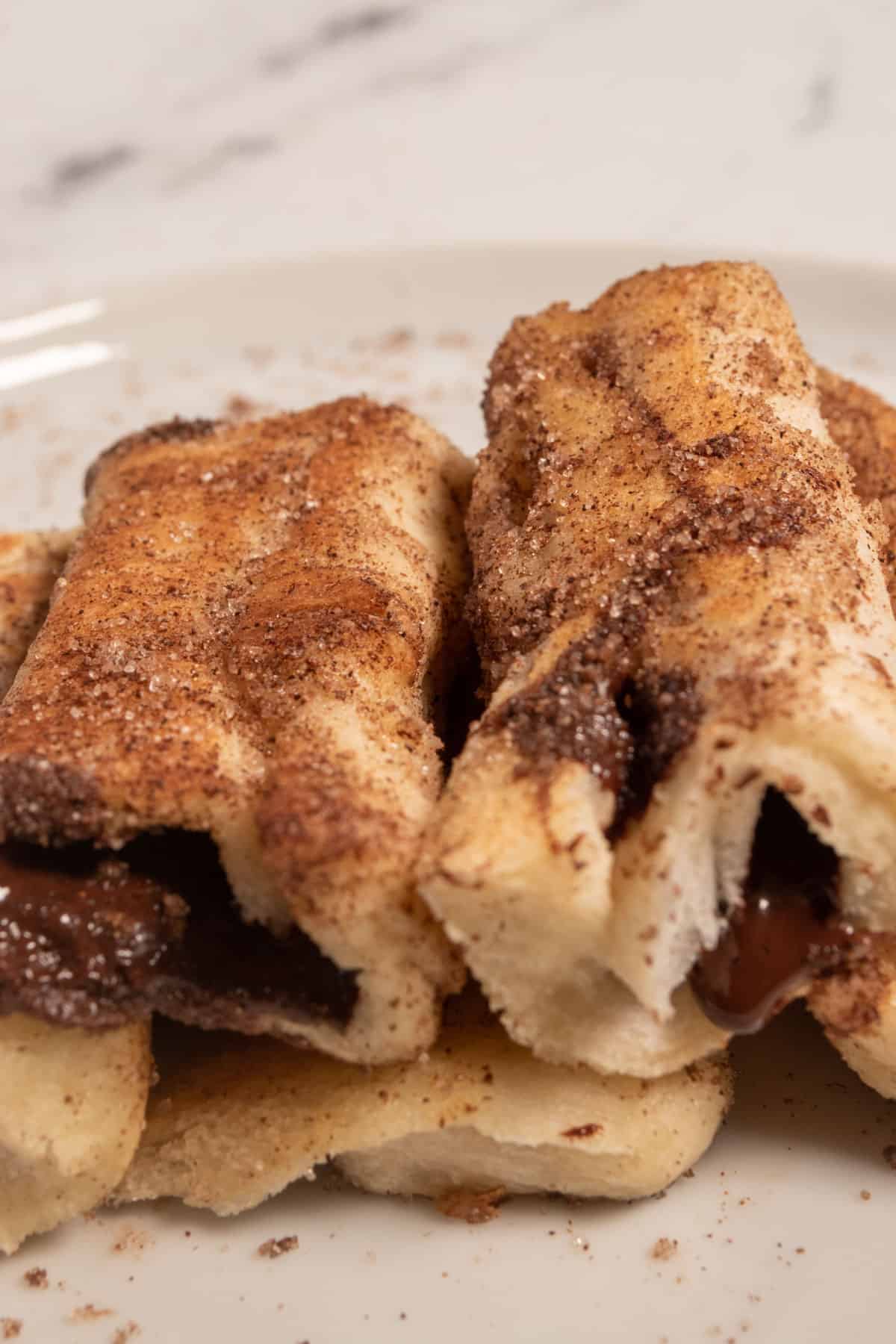 Golden brown chocolate french toast rolls covered with lots of cinnamon sugar. 