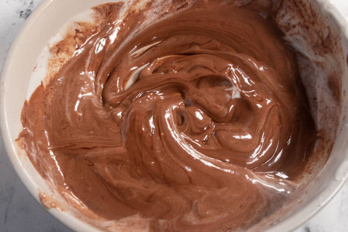 A bowl of chocolate yogurt. The vegan chocolate has been stirred into soy yogurt, creating a creamy mixture.