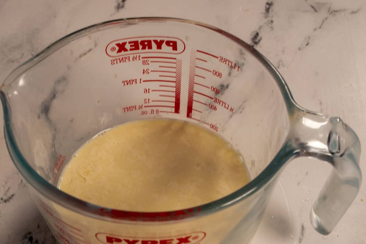 The vegan buttermilk curdling inside a large pyrex jug. 