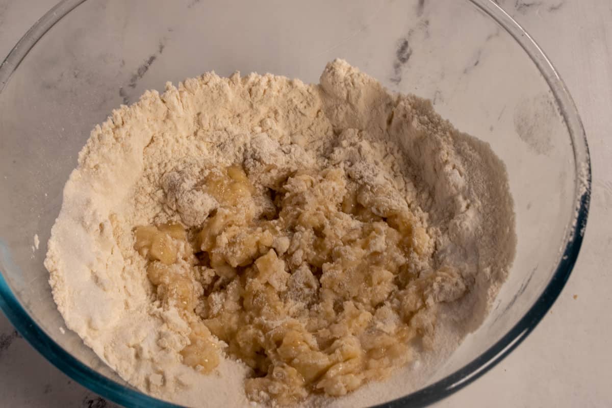 The dry ingredients, including the bananas combined inside a large, pyrex mixing bowl. 