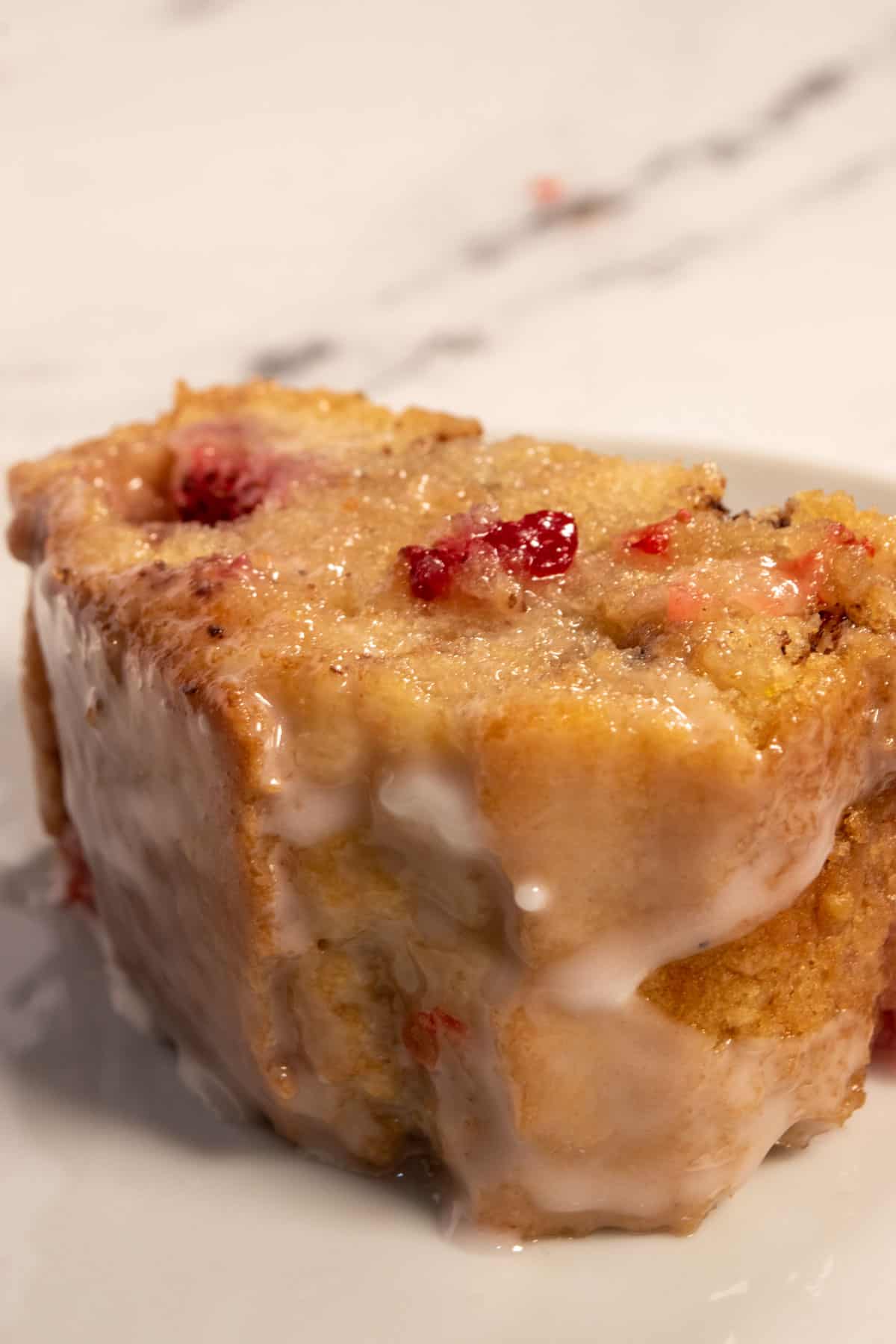 A large, golden brown slice of vegan strawberry cake on a serving platter. 