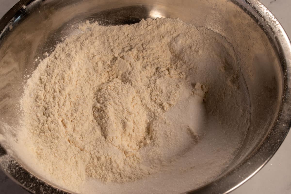 The dry cake ingredients inside a large, metal mixing bowl. 