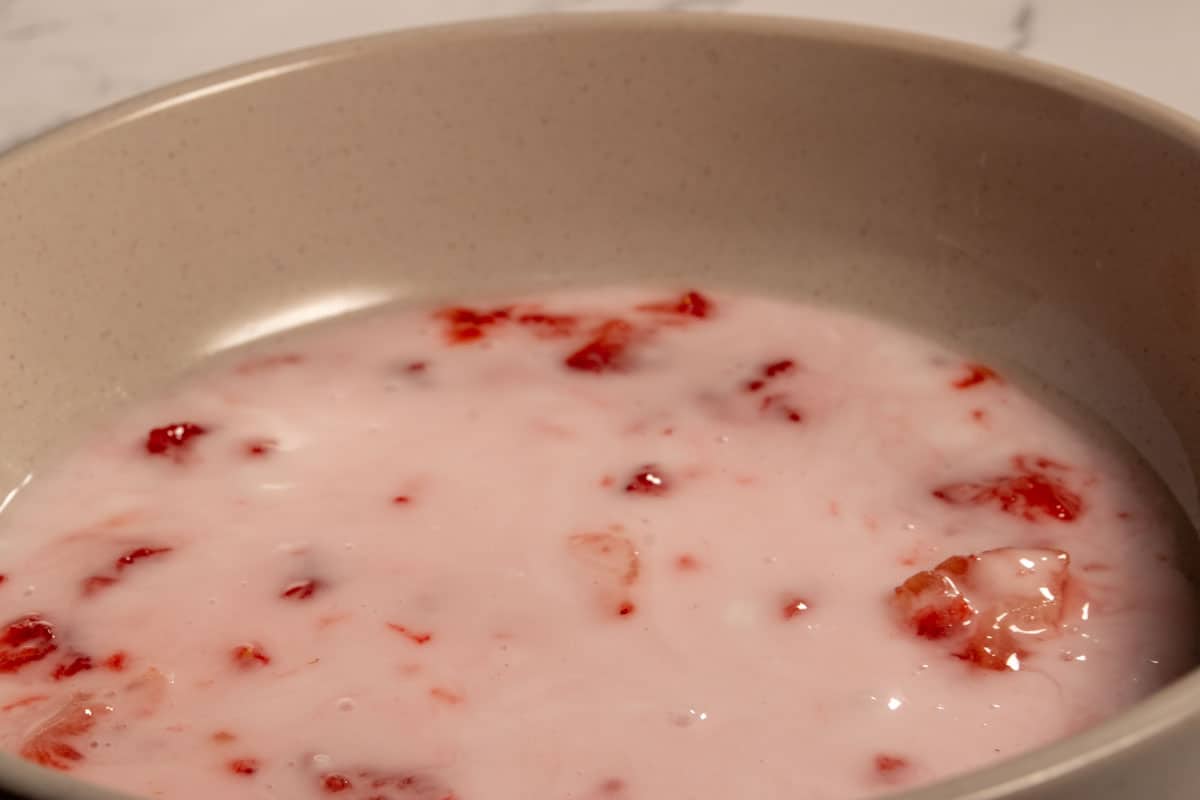 The strawberry glaze after being mixed together inside a grey bowl. 