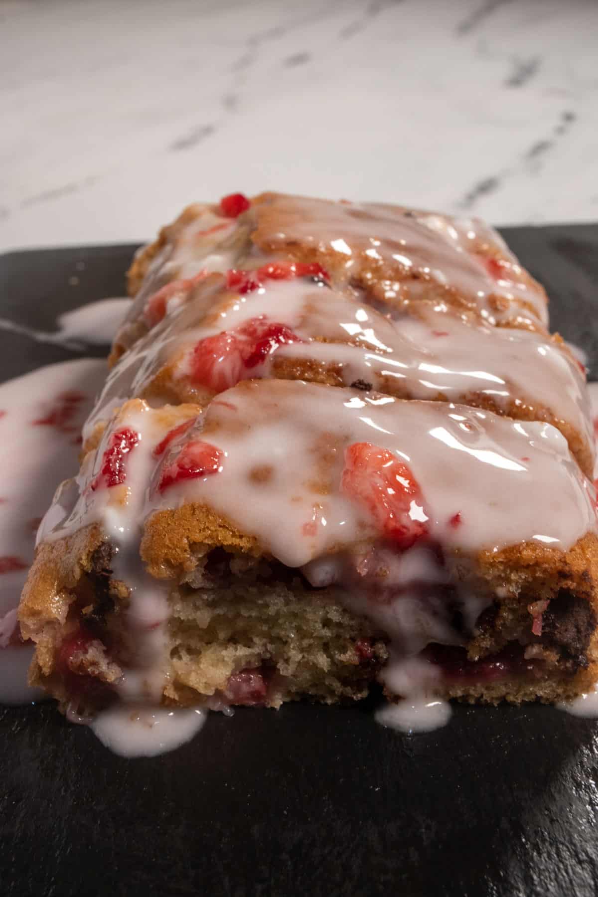 A whole loaf of strawberry chocolate chip cake which is covered with creamy strawberry glaze.