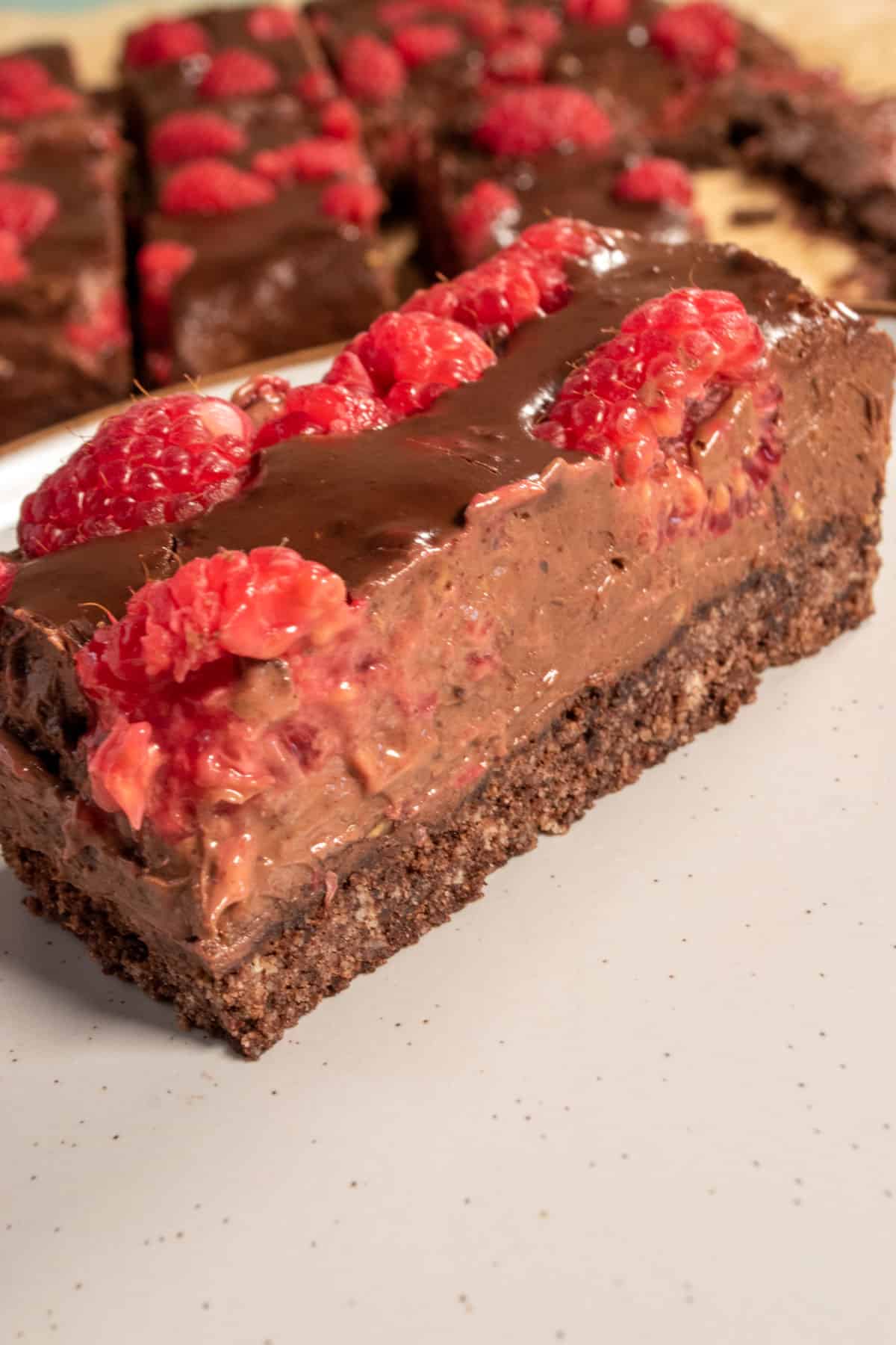One of my chilled chocolate raspberry bars. There are raspberries inside as well as on top. Many other bars are sitting in the background. 