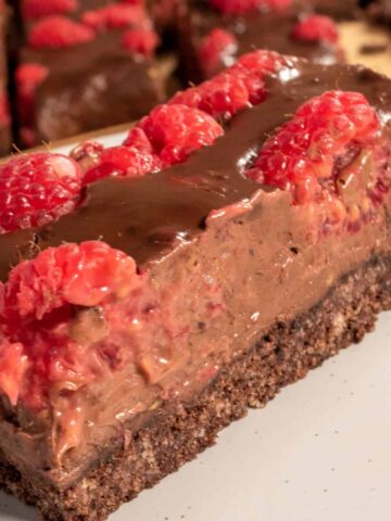 One of my large vegan nutella bars on a white. It is topped with juicy, fresh raspberries.
