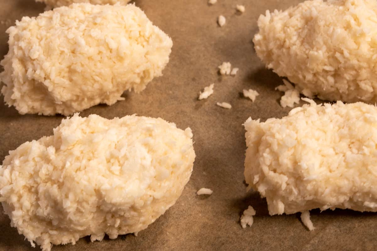 The coconut mixture has been squeezed together to create oblong shaped bars. 