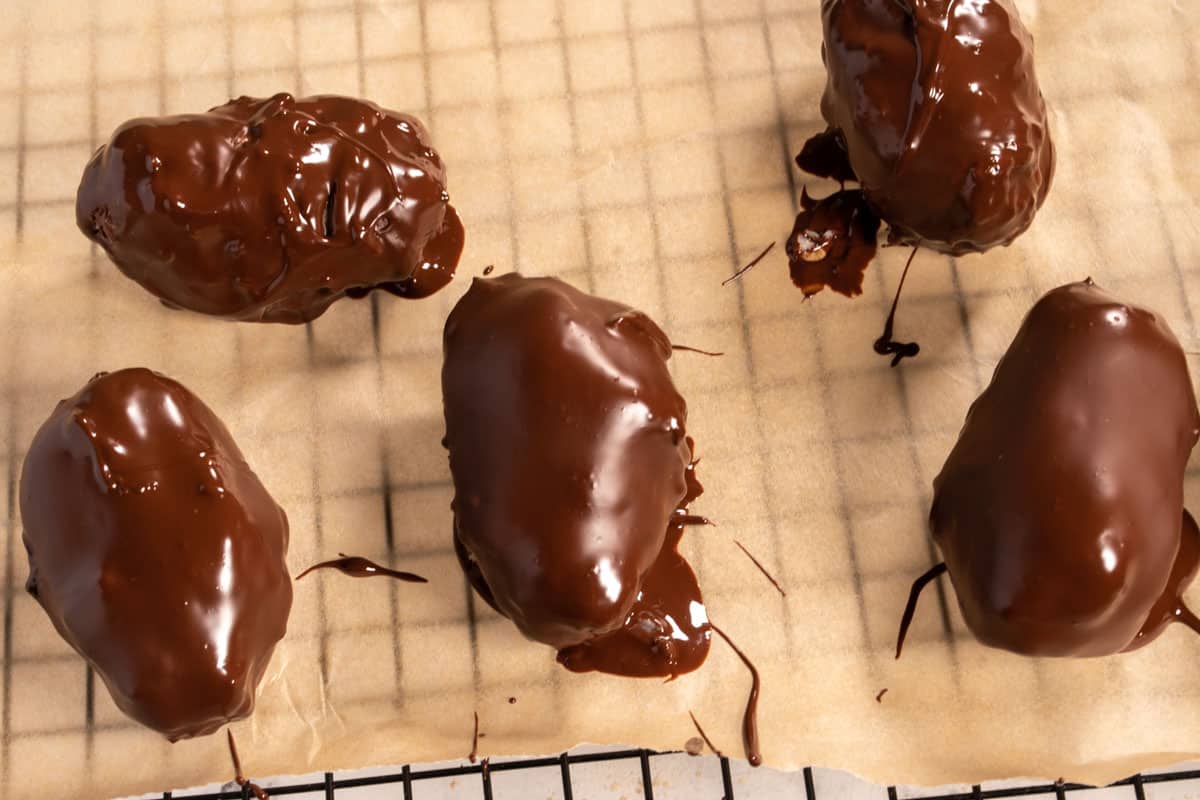 The frozen coconut bars have been dipped into the chocolate. 