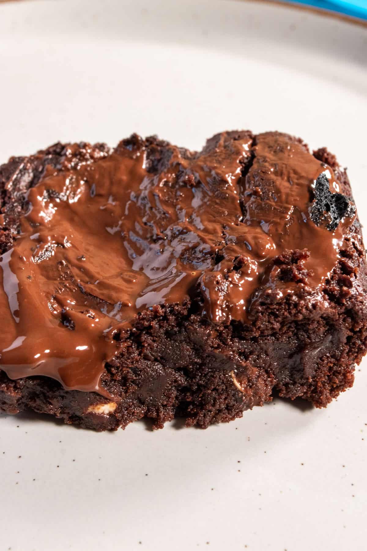 An overhead shot showing a fudgy slice of brownie. Chocolate drips down the side.