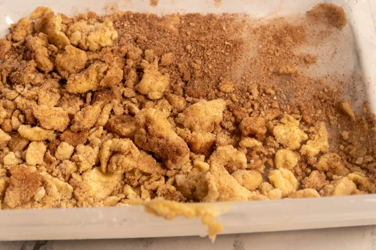 The cinnamon streusel inside a large, plastic container. 