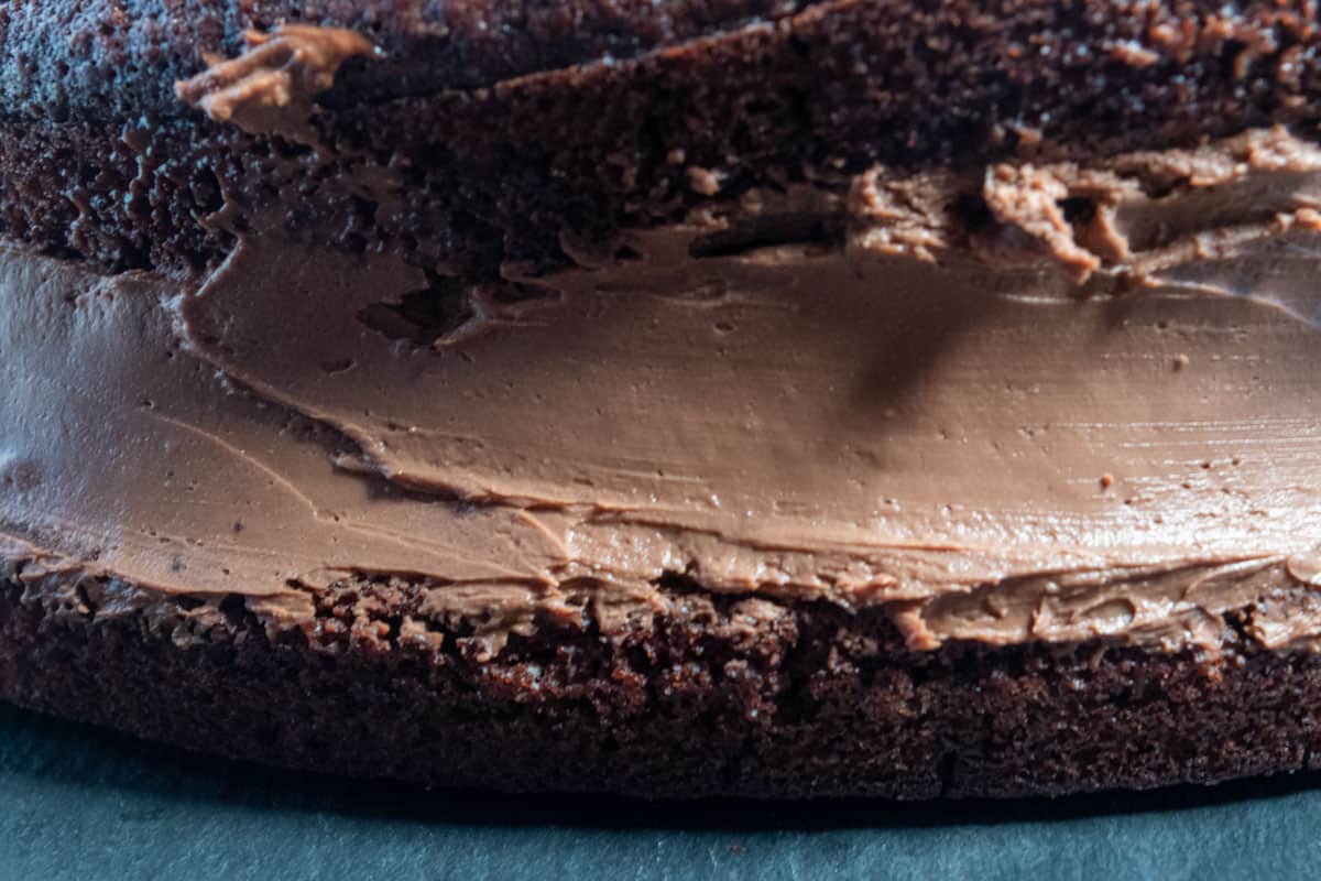 The mousse has been spread over the bottom cake half. The top half of the chocolate cake has been placed onto it to create a sandwich. 