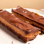 To long and rectangular slices of my vegan chocolate peanut butter bars on a serving plate.