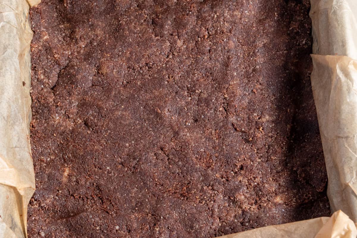 The chocolate almond mixture has been pressed into the base of the lined tin. 