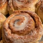 Vegan cinnamon rolls inside a pan just after being glazed.