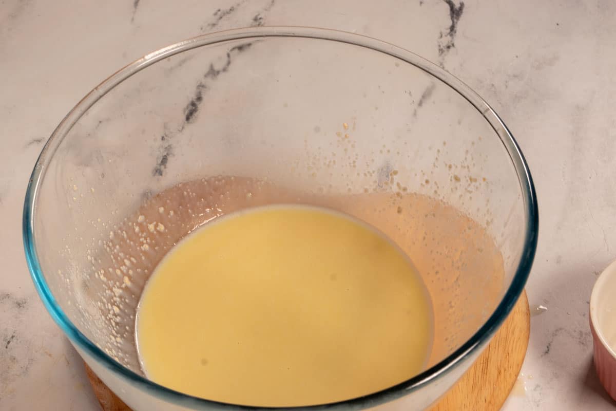 The yeast has been added to the wet ingredients inside a bowl.