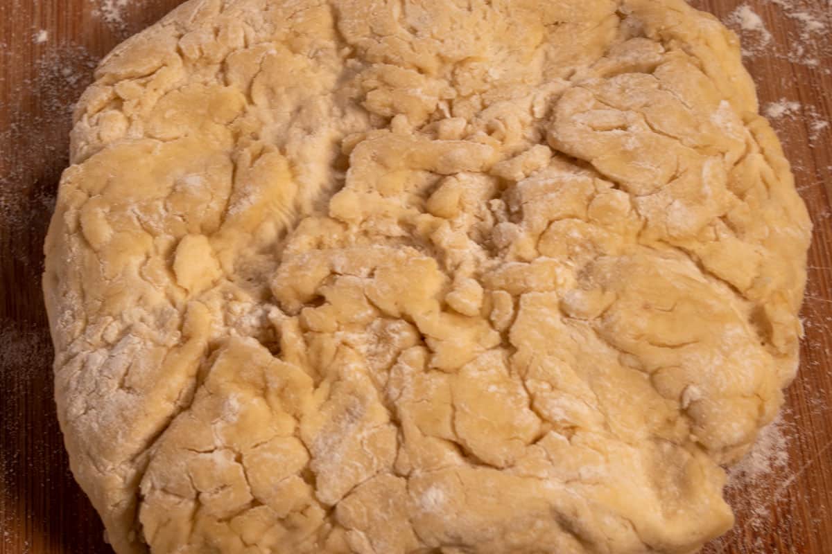 The risen dough is laid out on a wooden board. 