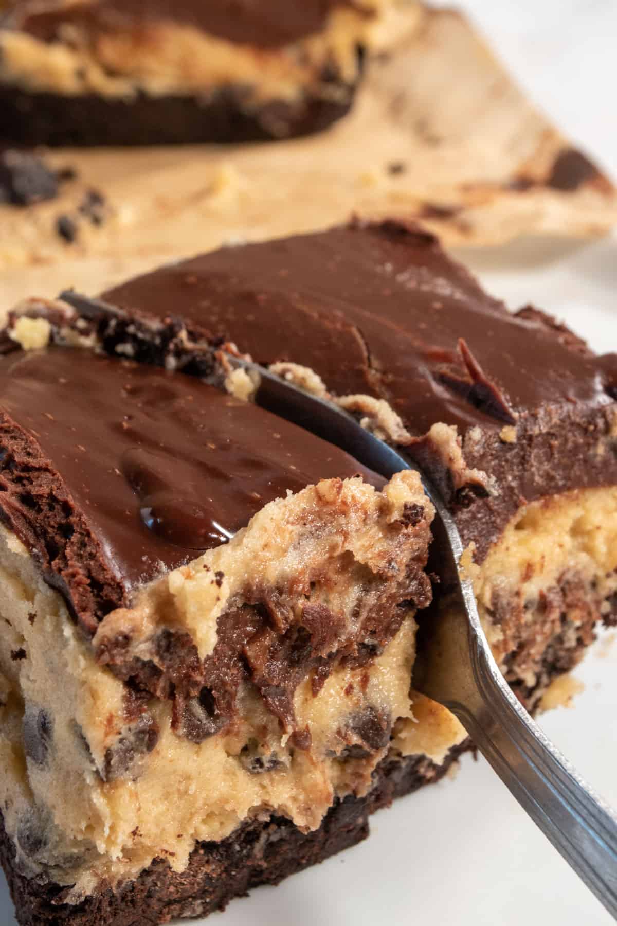 A smaller piece of my vegan cookie dough bars being sliced with a fork. It's so gooey.