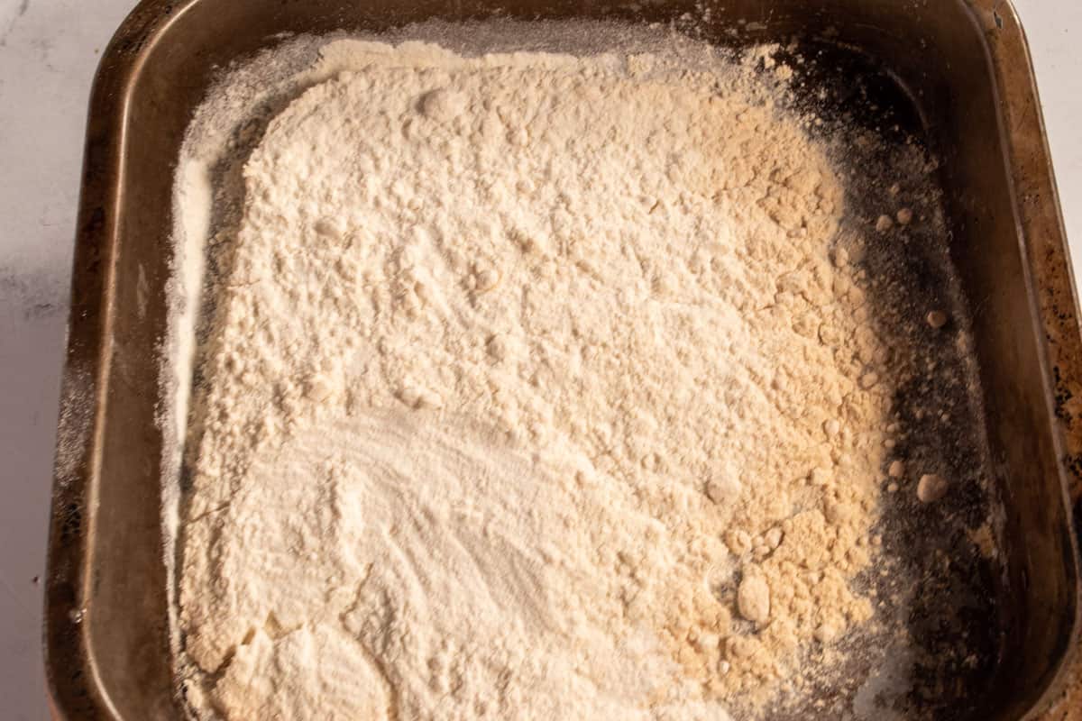 Heat treated flour inside a small metal tray. 