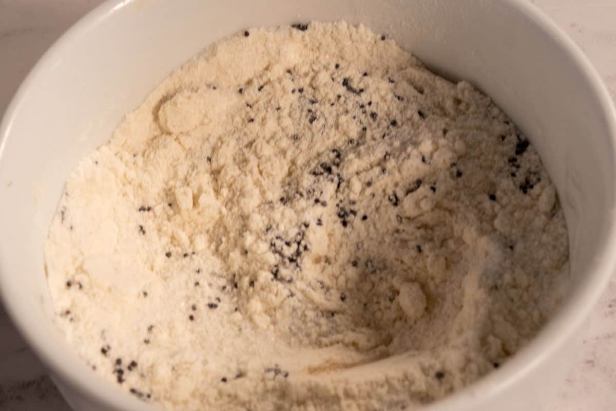 The dry mug cake ingredients, including the poppy seeds combined inside a white ramekin.