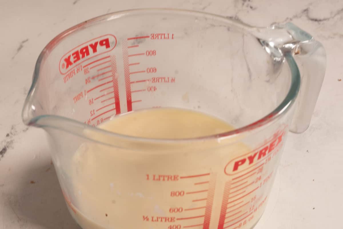 The vegan buttermilk curdling in a pyrex jug.