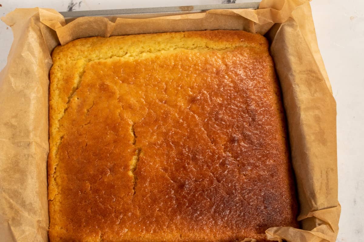 A golden brown baked lemon cake cooling down after leaving the oven. 