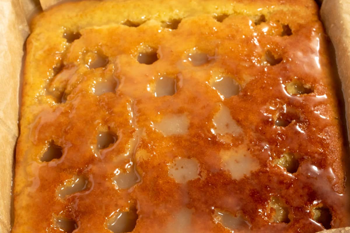 The condensed milk has been poured into the holes. It is soaking into the cake. 