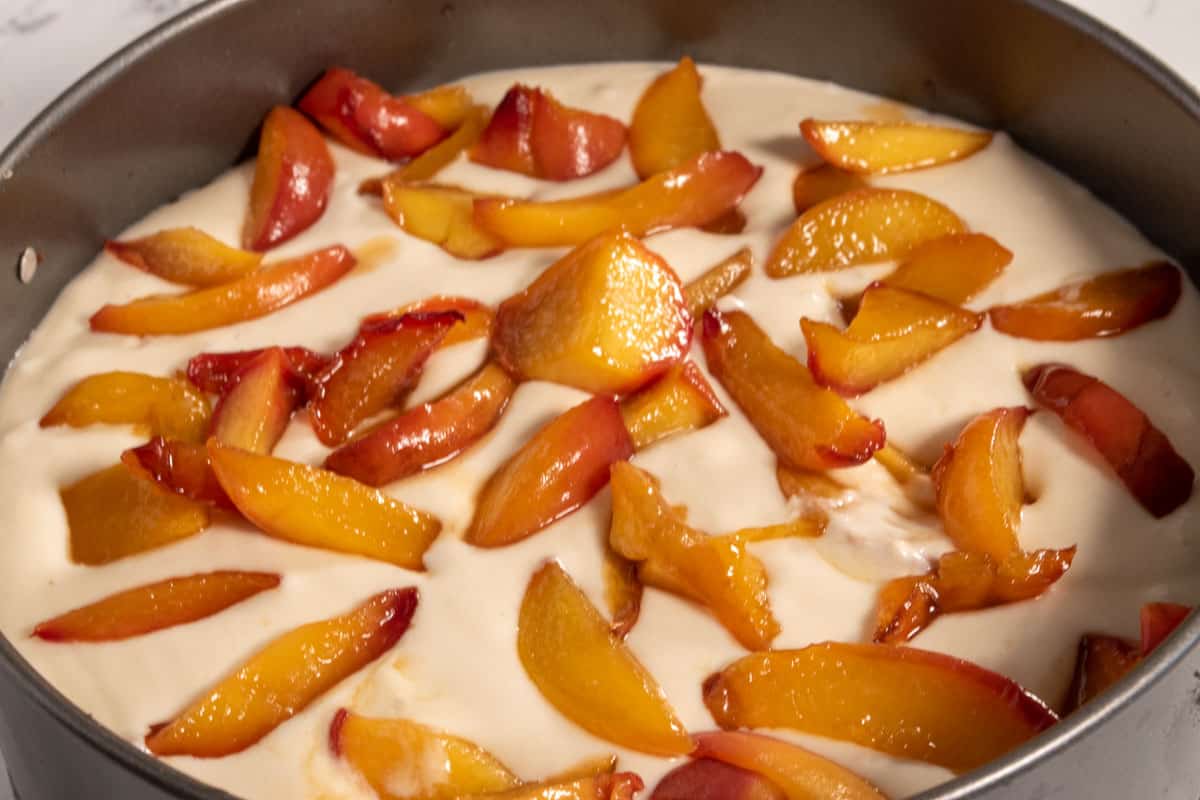 The cheesecake filling has now also been made. It has been poured over the base and topped with the peaches.