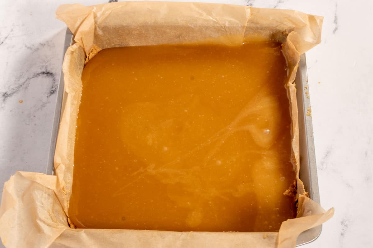 The caramel layer has been poured over the base and is setting. 