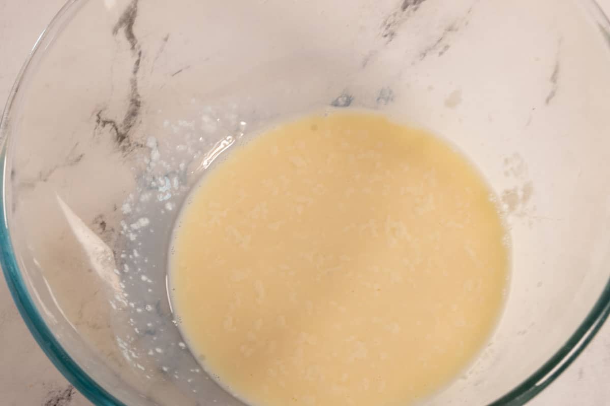 The vegan buttermilk curdling inside a large pyrex bowl. 