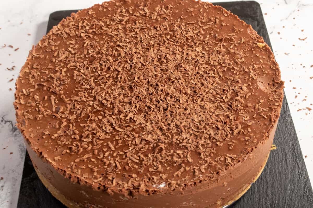 The chocolate cheesecake has set and has been sprinkled with chocolate shavings. 