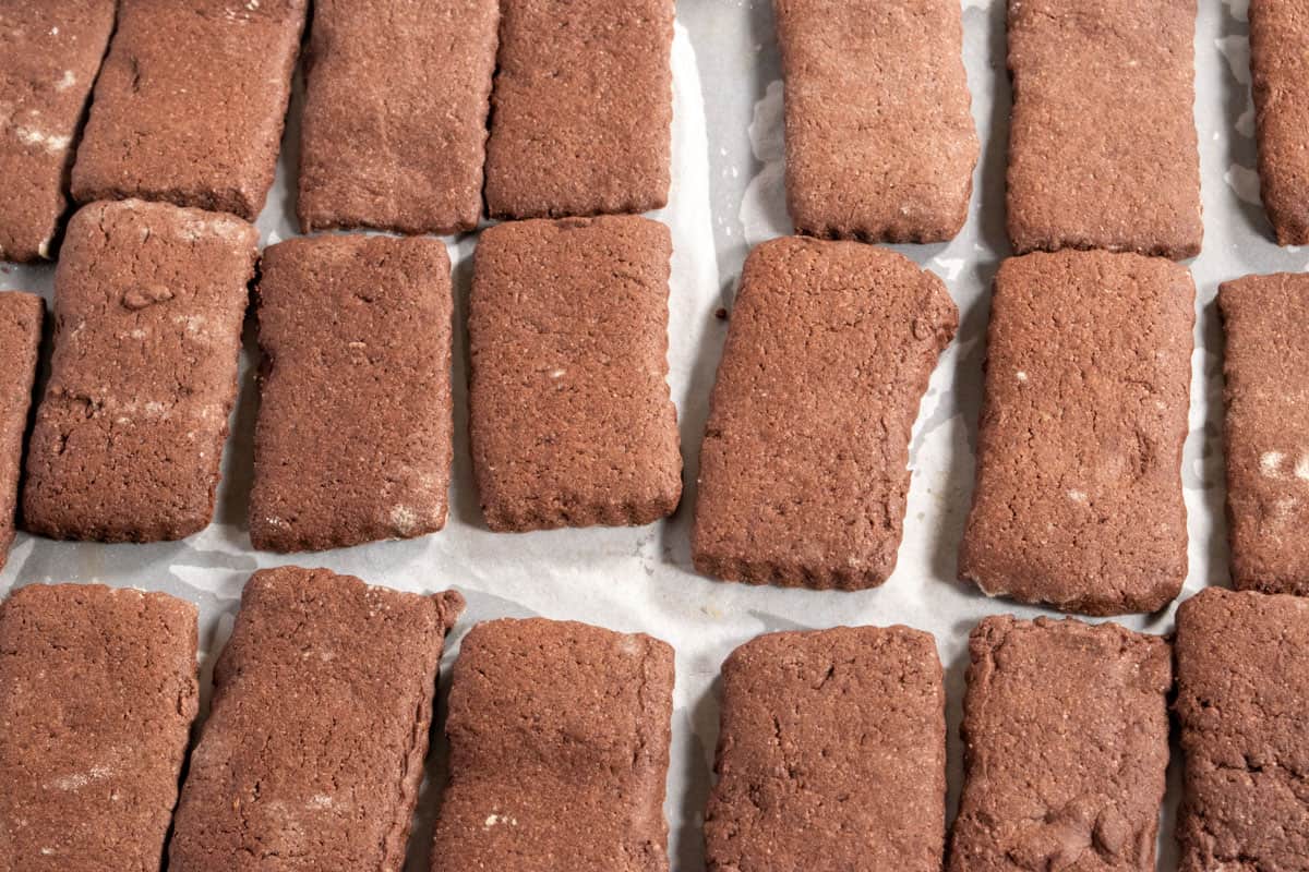 Baked vegan chocolate wafer cookies cooling down on a baking tray. 