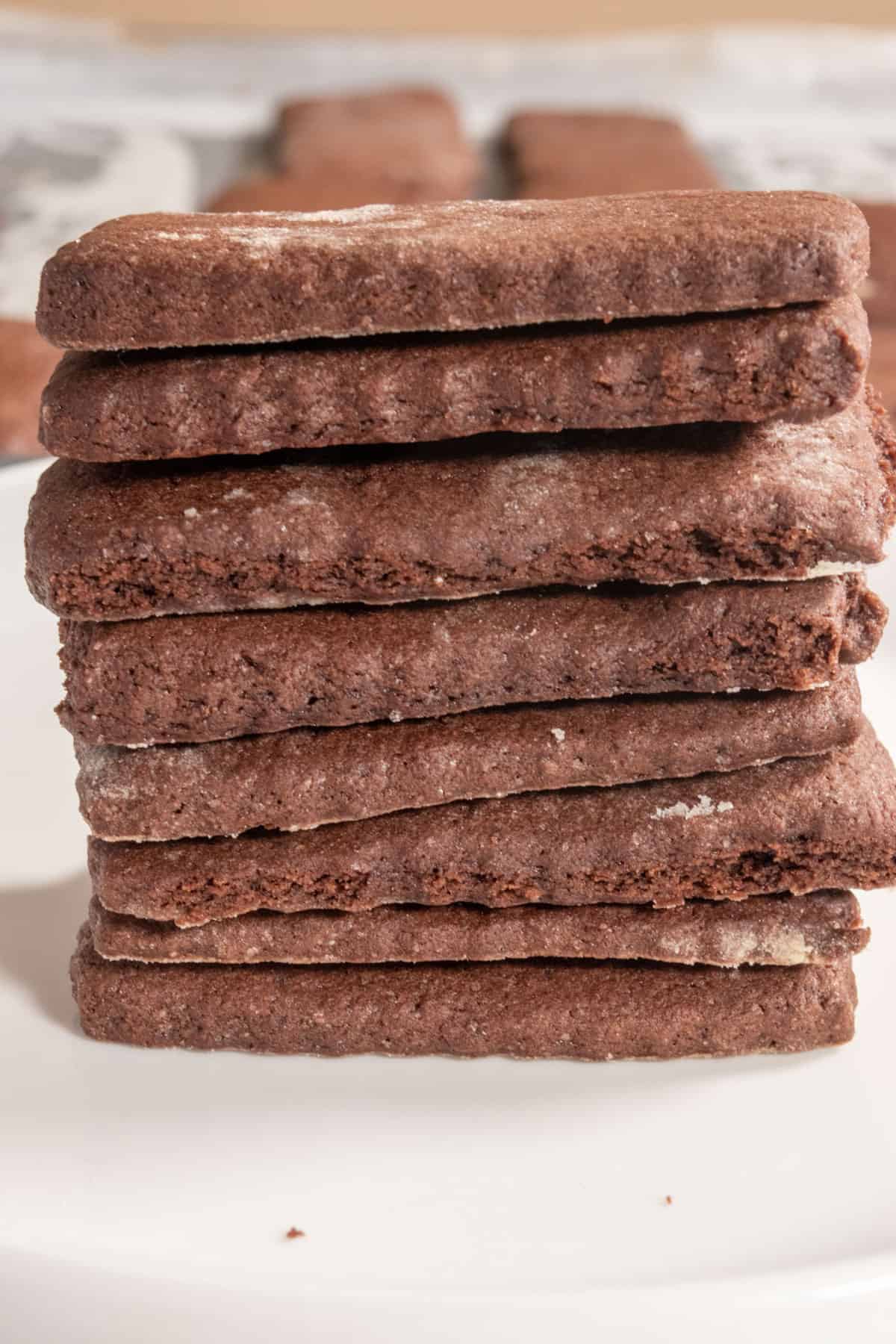A tall stack of vegan chocolate wafer cookies very close up to the camera on a serving platter.  