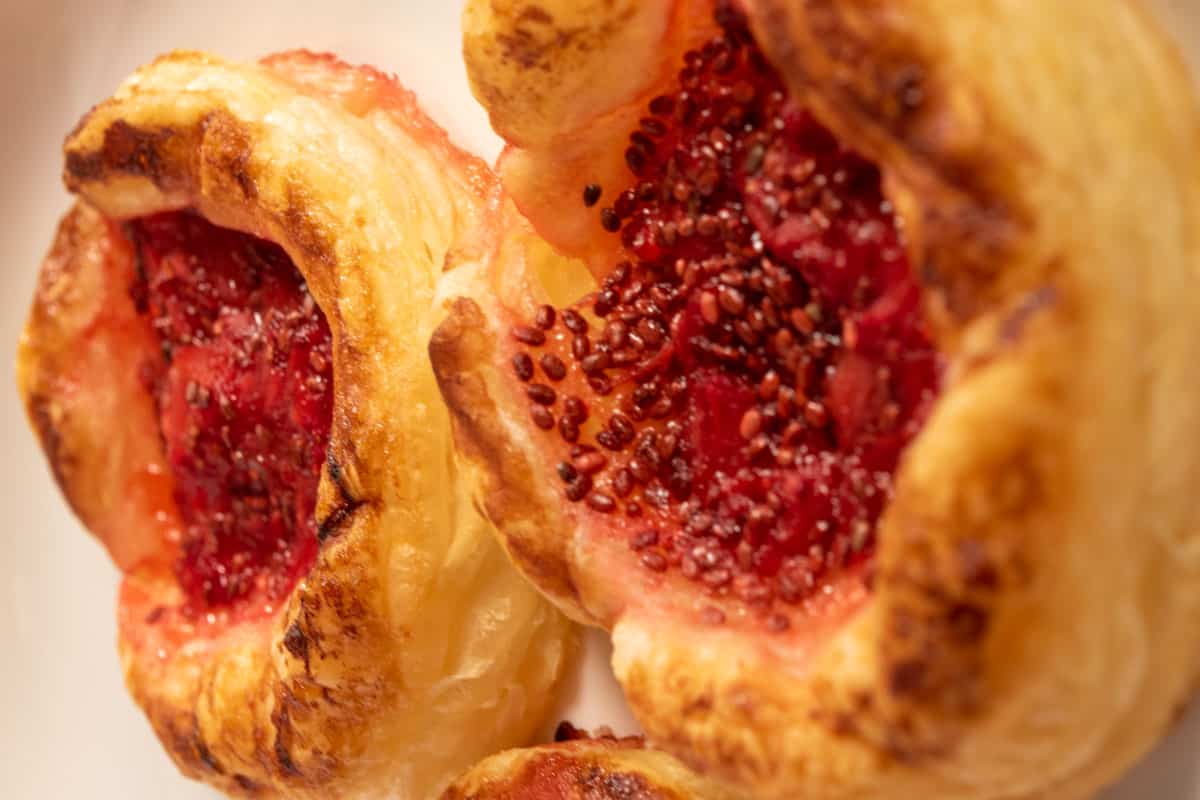 Golden brown baked pastries cooling down on a white plate. 