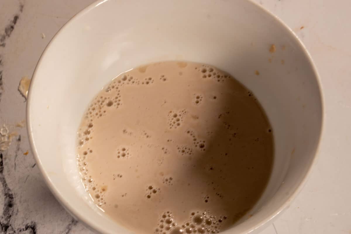 The yeast mixture inside a small bowl.