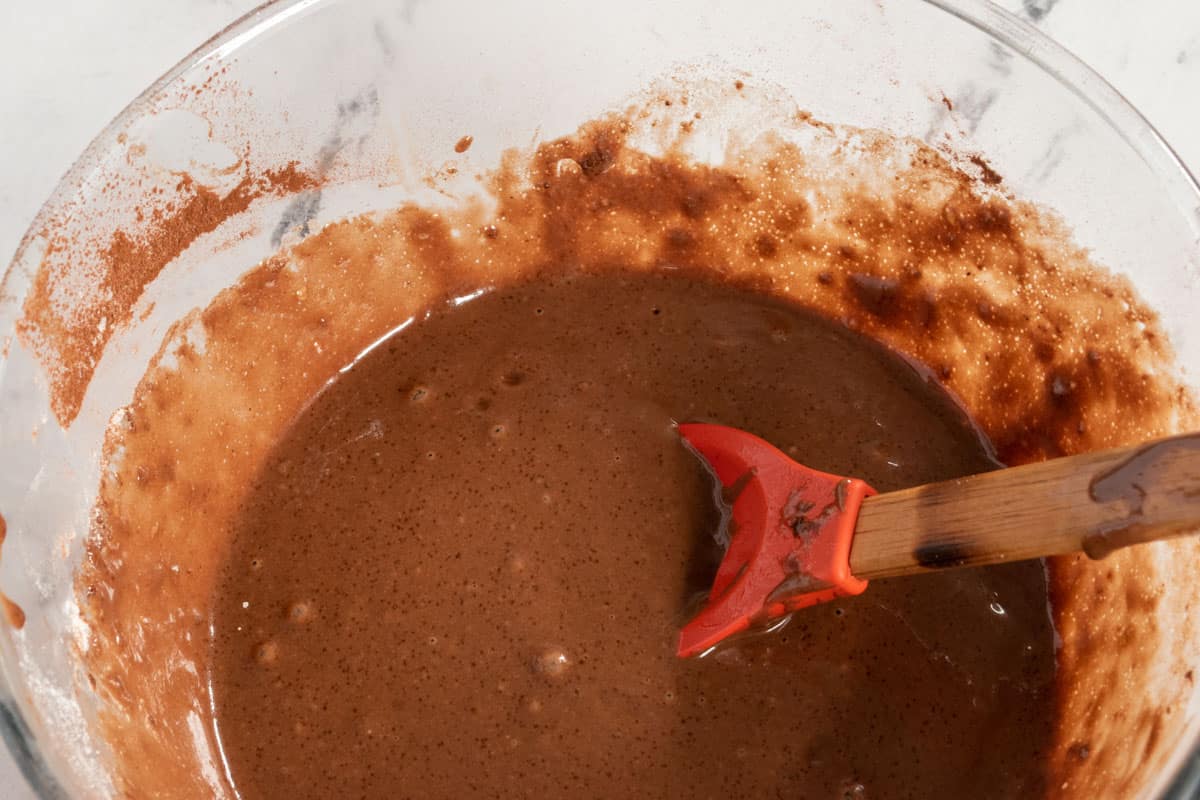 The dry and wet ingredients have been folded together, forming a smooth chocolate cake batter.