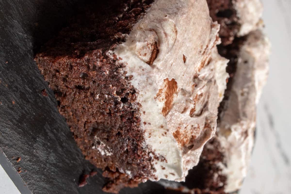 The frosting has been spread over the chocolate cake and sliced. 